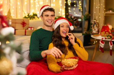 Eşler Xmas filmleri izler, battaniyeye sarılır ve patlamış mısır yerler. Noel akşamı eğlencesi ve sinema zamanı.
