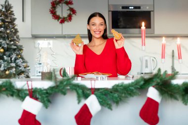 Kazaklı güzel bir kadın ev yapımı zencefilli kurabiye tutuyor ve kameraya gülümsüyor, Noel 'i evde kutluyor.