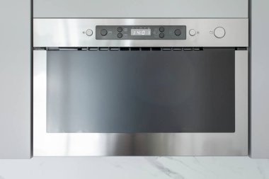 Modern paslanmaz çelik, mikrodalga fırın, minimalist tasarım ve dijital kontrol paneli içinde şık pişirme teknolojisi.