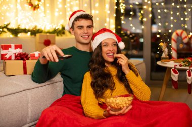 Heyecanlı eşler Noel arifesinin tadını çıkarıyor, televizyon izliyor, patlamış mısır yiyor, evde oturuyor. Yeni yıl ve Noel kutlaması konsepti