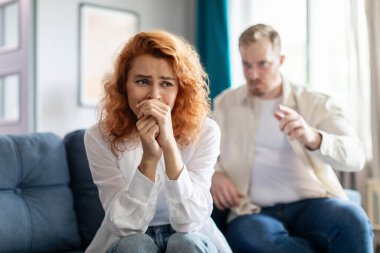 Duygusal sinirli bir adam karısıyla el kol hareketi yapıyor, tartışıyor, genç bir çift evde kavga ediyor, kanepede oturuyor.