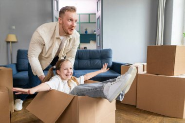 Mutlu baba yeni evinde kızıyla eğleniyor, kapalı mekanda kutularla oynuyor. Emlak, konut kredisi konsepti