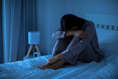 Depresyon, akıl sağlığı sorunu. Genç bir kadın geceleri yatakta depresyonda ya da uyuyamıyor.