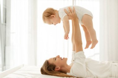 Mutlu anne kaldırma ve küçük kızıyla oynama, anneliğin tadını çıkar ve evde birlikte vakit geçir, boş yer.