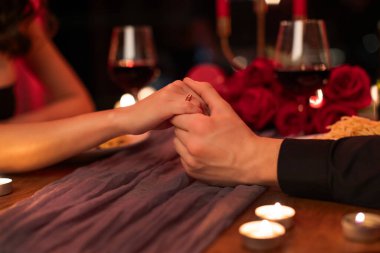 Romantik evlilik teklifi. Nişan yüzüğü takan kadın, kadın eli tutan erkek, evlenmeye karar veren çift, yakın plan.