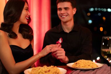 Teklif akşamı. Mutlu adam nişan yüzüğünü kız arkadaşının eline takıyor. Çiftin restoranda romantik bir akşam yemeği yiyor. Sevgililer Günü.