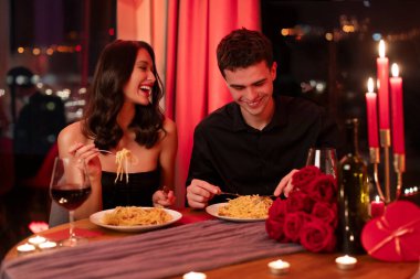 Yakışıklı adam ve güzel kadın restoranda akşam yemeği yiyorlar, Sevgililer Günü 'nü birlikte kutluyorlar, aşıklar akşam yemeğinin keyfini çıkarıyorlar.