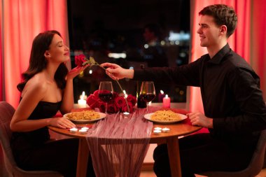 Sevgili bir kadına gül veren, sevgililer gününde restoranda romantik bir randevusu olan genç bir adam. Aşk ve aşk kavramı