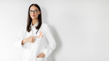 Female doctor pointing at orange ribbon showing symbol of Uterine Cancer Awareness, panorama with free space clipart