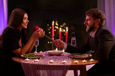 Sevgi dolu bir adam sevgilisine gül veriyor, Sevgililer Günü 'nde romantik bir randevuya çıkıyor, restoranda fotoğraf çekiyor.