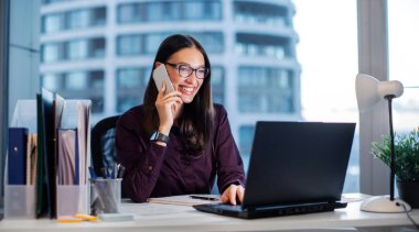 Dost canlısı iş kadını, üst düzey yönetici müşteriyle veya çalışanlarla konuşuyor ve dizüstü bilgisayar ekranına gülümsüyor, panorama