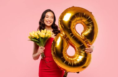 8 numaralı balonlu ve çiçek buketli zarif bir kadın. Kadın Günü 'nü kutluyor. Pembe stüdyo arka planında bahar tatilinin tadını çıkarıyor.