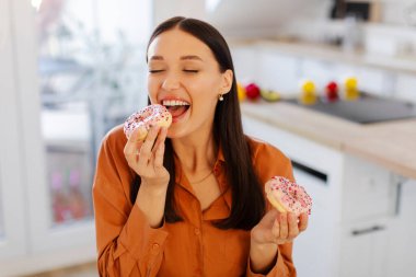 Hile yemeği. Aç bir kadın donut yiyor, evde abur cubur yiyor. Sağlıksız beslenme ve aşırı yeme alışkanlığı