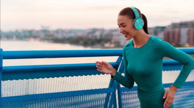 Mutlu bayan dışarıda çalışmaktan, şehir köprüsünde koşmaktan ve kulaklıkla müzik dinlemekten hoşlanır. Etkin yaşam tarzı kavramı