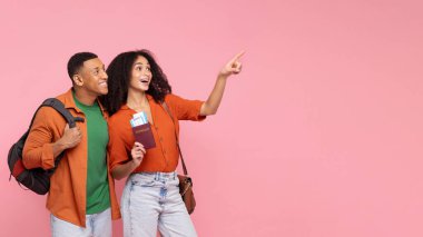 Sıcak tur teklifleri. Heyecanlı Latin turistler, boş alanı gösteriyorlar, harika bir seyahat teklifi sunuyorlar, kadın pasaport tutuyor, erkek sırt çantası taşıyor.