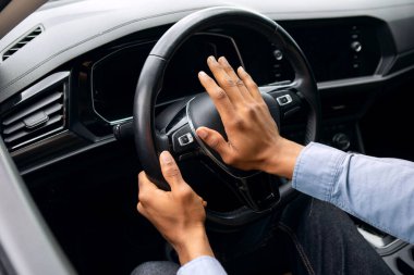Genç siyah adam araba sürerken korna çalıyor, arabada oturuyor, direksiyonu tutuyor, otomatik olarak kornaya basıyor.