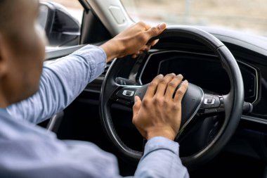 Araba sürerken siyah adamın kornaya basmasını, erkek sürücünün kornaya basmasını. Ulaşım ve trafik kavramı