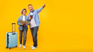 Heyecanlı turistler tatile çıkıyor, harita, bavul, pasaport ve uçak biletleriyle duruyorlar, boş fotokopi alanını gösteriyorlar, seyahat tekliflerini gösteriyorlar.