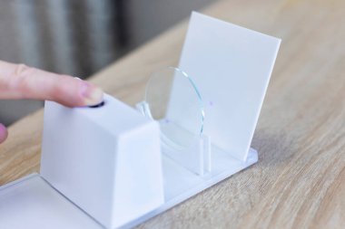 Optik klinikte fotokromik gözlük lenslerini kontrol eden göz doktoru, yakın çekim.