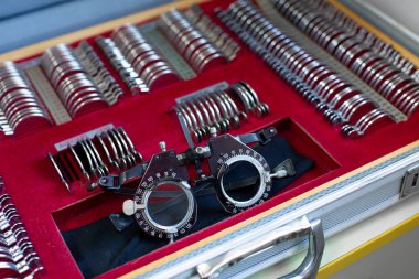 Klinikteki vizyonu kontrol etmek için optometrist araçlar ve gözlüklerle davanın görünümünü kapat