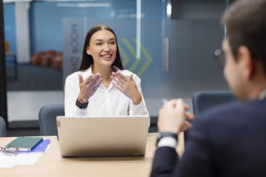 İki genç iş arkadaşı iş projesini tartışıyor, modern ofis yönetim kurulunda toplanıyorlar, iş kadını ve iş adamı beyin fırtınası yapıyorlar.