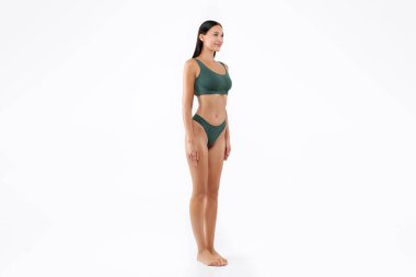 Beyaz stüdyo arka planında izole edilmiş, yeşil iç çamaşırlı, mükemmel vücut şekli olan zayıf bir kadının vücut boyu.