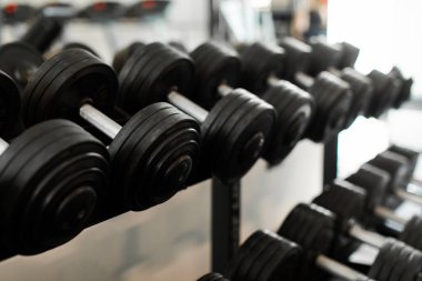 Modern spor salonunda siyah çelik halterleri yakın çekim yapın. Antrenman ve vücut geliştirme ekipmanları