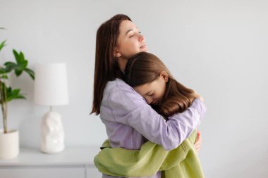 Ebeveyn-çocuk ilişkisine güven. Şefkatli anne üzgün ergen kızını kucaklıyor, zor zamanlarda çocuğunu destekleyen kadın, empati ve anlayış gösteriyor.