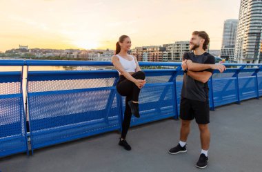 Çift dışarıda antrenman için ısınıyor, koşucular antrenmana hazırlanıyor ya da şehir köprüsünde koşuyor, kopyalama alanı var.