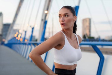 Genç sporcu bayan koşucunun portresi akşam antrenmanında ya da akşam kardiyo antrenmanına hazırlanıyor.