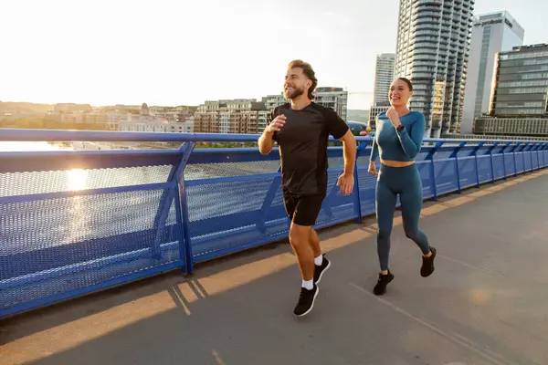 Sabahın köründe koşu. Genç Avrupalı çift şehir köprüsünde koşuyor, birlikte antrenman yapıyorlar, boşluğu kopyalıyorlar.