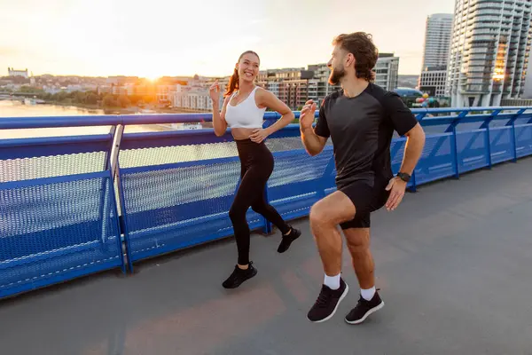 Atletizm sporcusu kadın ve erkek şehirde birlikte koşuyor, akşam sporu antrenmanı yapıyorlar, uzun mesafe atışı, fotokopi alanı.