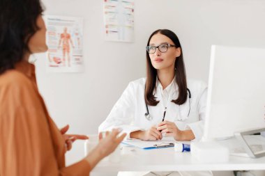 Ofiste çalışan ve kadın hastaları dinleyen profesyonel bir kadın doktor. Bu arada bayan da semptomlarını açıklayıp danışmanlık yapıyor.