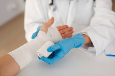 Yaralı kadınları bandajla saran doktor. İlk yardım ve profesyonel uzuv yaralanması tedavi konsepti