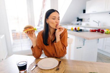 Lezzetli yemek servisi yapan, parmaklarını yalayan, tatminini sunan ve mükemmel zevki olan aç bir kadın.