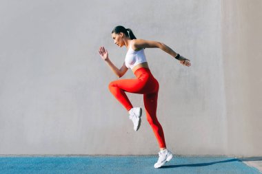 Sporcu kadın dışarıda egzersiz, spor eğitimi ve sağlık eğitimi için ısınıyor, güneşli bir günde dışarıda bayan antrenmanı yapıyor.