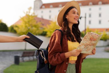 Kadın turist çantasından cüzdan çalan yankesici hırsızı. Bu arada elinde harita tutan ve hayran olunan tarihi binalara bakan kadın.