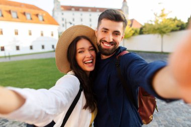 Sevgi dolu genç bir çift. Sarılmak ve selfie çekmek. Şehir caddesinde yürürken ve gezerken.