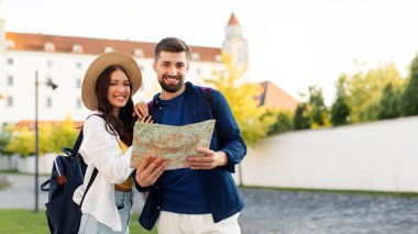 Kasabayı gezmek, sokaklarda yürümek ve birlikte seyahat etmek için harita kullanan Avrupalı iki gezginin portresi.
