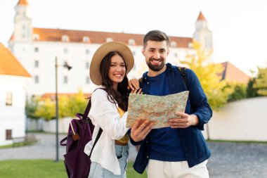 Kasabayı gezmek, sokaklarda yürümek ve birlikte seyahat etmek için harita kullanan Avrupalı iki gezginin portresi.