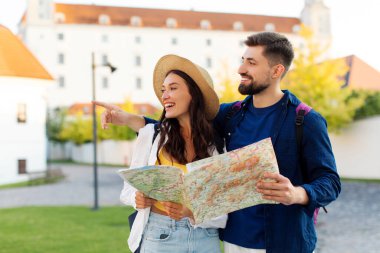 Mimarlıktan hoşlanan bir çift, eski şehir sokaklarında gezerken ve dolaşırken, elinde harita tutan ve işaret eden bir adam, serbest alan