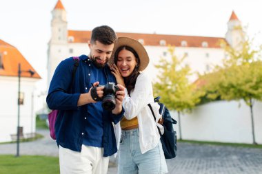 Gülümseyen adam ve kadın birlikte seyahat ediyor, çift romantik bir yolculukta fotoğraf çekiyor, eğleniyor ve anları yakalıyor.