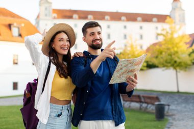 Mimariden zevk alan turist bir çift, kadın ve erkek eski şehir sokaklarında yürüyor, adam haritayı işaret ediyor ve tutuyor.