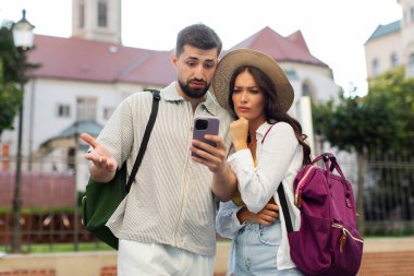 Birkaç turist, şehir rehberine danışırken, akıllı telefon GPS 'leri kullanırken, sokakta dikilirken ve mekanları ararken sorun yaşıyor.