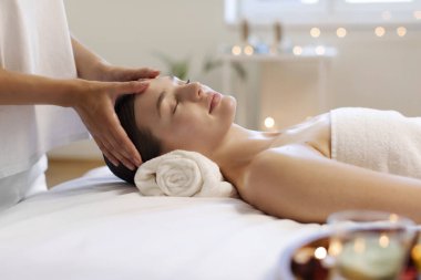 Spa 'da kadının hassas yüz masajı yaptırdığı rahatlatıcı bir sahne. Rahatlamış tavrını ve rahatlığını sergiliyor.