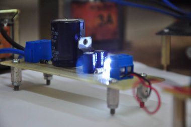 Voltaj devrelerinin yan görüntüsü. Bu devre AC voltajını DC 'ye çeviriyor. Soket kabloları, diyotlar, kapasitörler, IC düzenleyiciler, rezistörler ve LED 'lerden oluşur