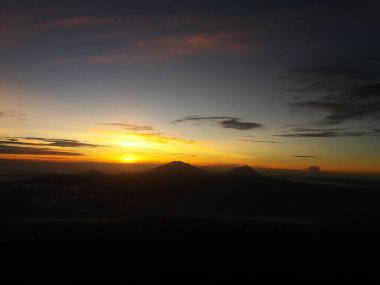 Gün doğumunda güzel gökyüzü, uzaklardan dağları görebilirsin.