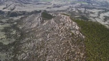 A side of a mountain in a desert place with view for miles and miles.