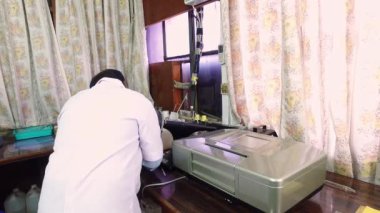 Bangalore, Hindistan-Nisan 7 2016: Laboratuvarda makinelerle çalışan bilim adamı veya endüstri araştırmacısı. Kalite kontrol laboratuvarı. Araştırma laboratuvarı.