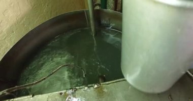 Closeup of separating sandalwood oil from liquids inside the factory